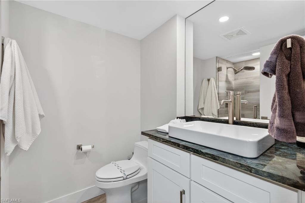Bathroom with vanity, a shower, and recessed lighting