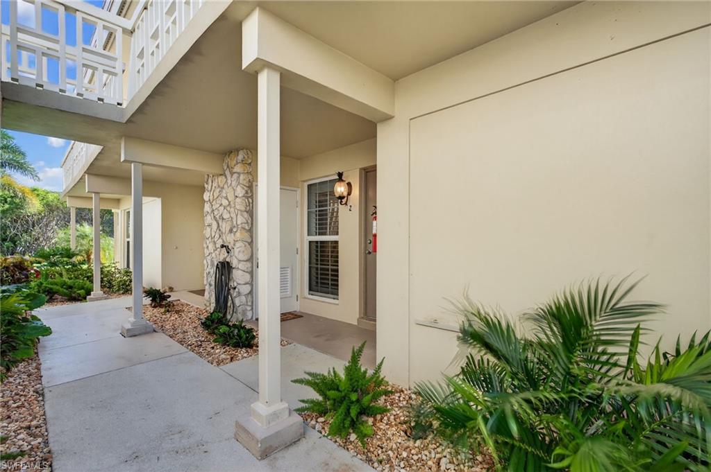 View of exterior entry featuring stucco siding and a porch