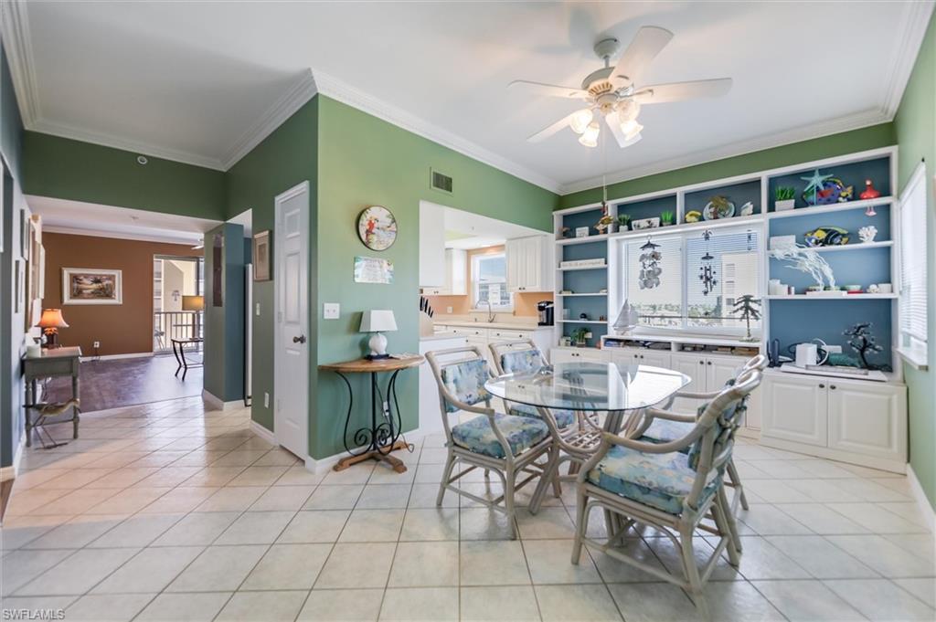 Dining room with ornamental molding, light tile patterned flooring, and ceiling fan