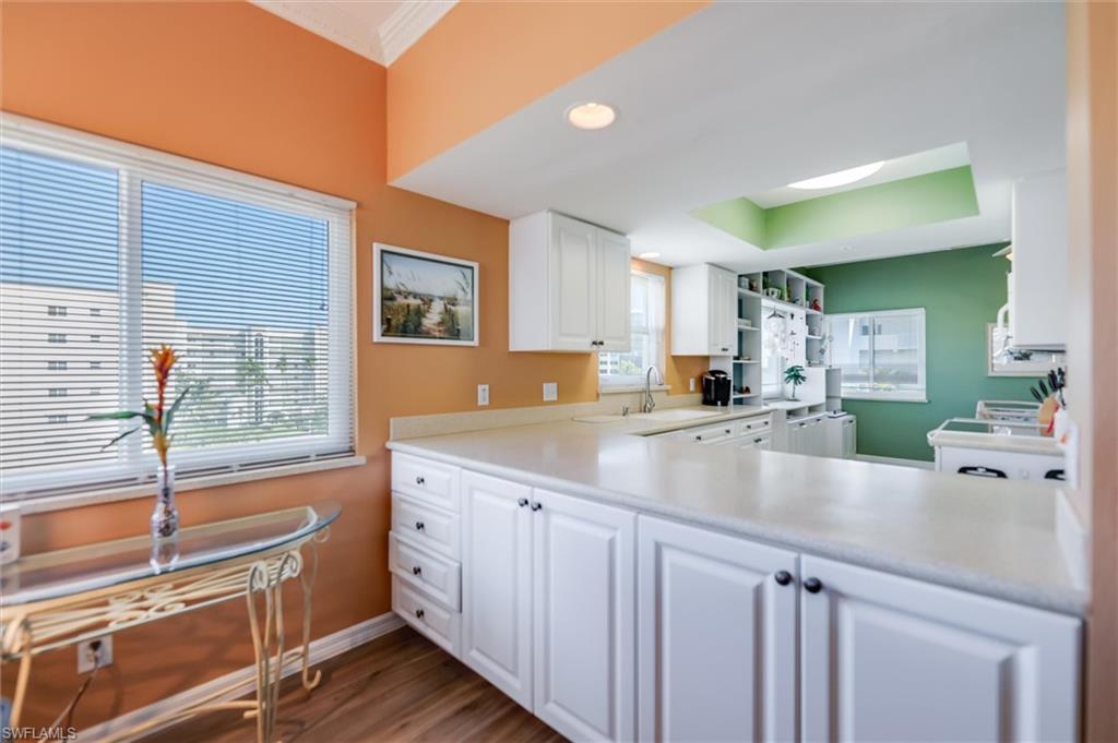 Kitchen featuring white cabinets, dark wood-style floors, and light countertops
