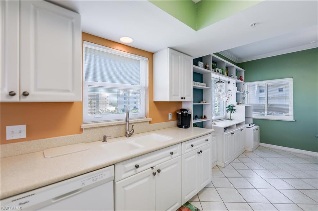 Kitchen featuring white cabinetry, dishwasher, light countertops, light tile patterned floors, and open shelves