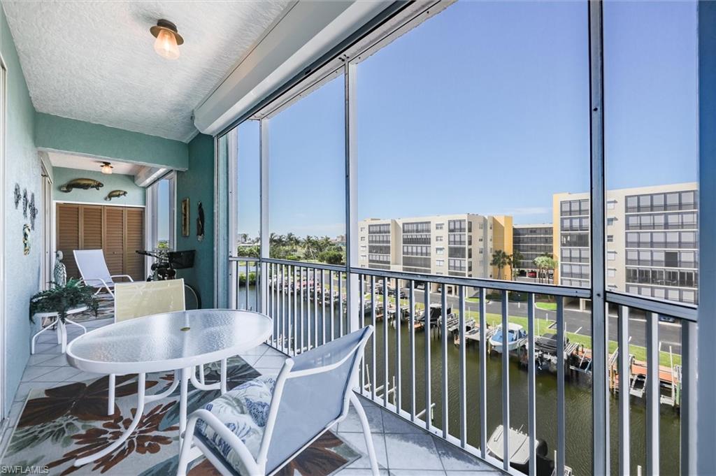 Balcony featuring a sunroom and a water view