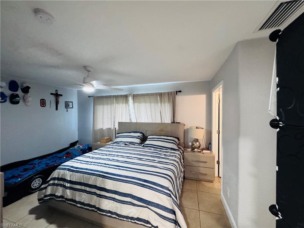 Bedroom with light tile patterned flooring and ceiling fan