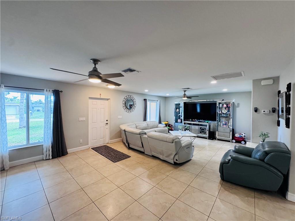 Living room with light tile patterned floors and ceiling fan