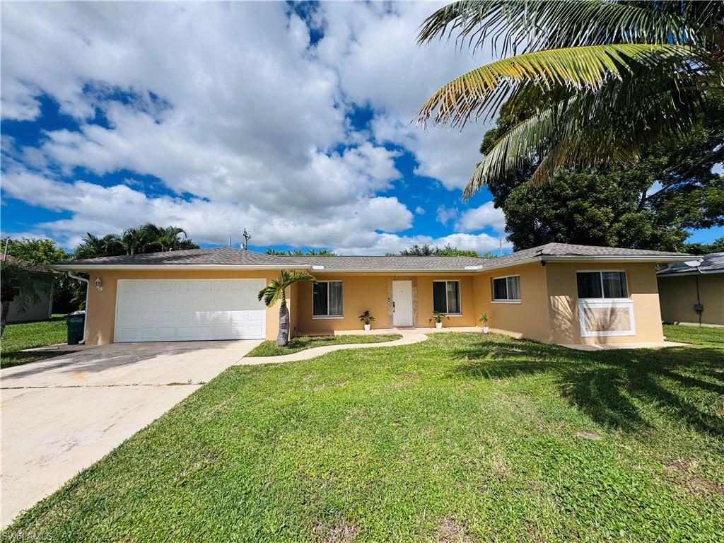 Ranch-style home featuring stucco siding, driveway, a front lawn, and an attached garage