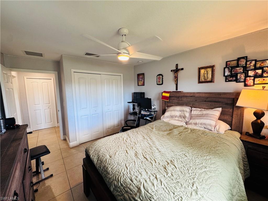 Bedroom with light tile patterned flooring, a closet, and a ceiling fan