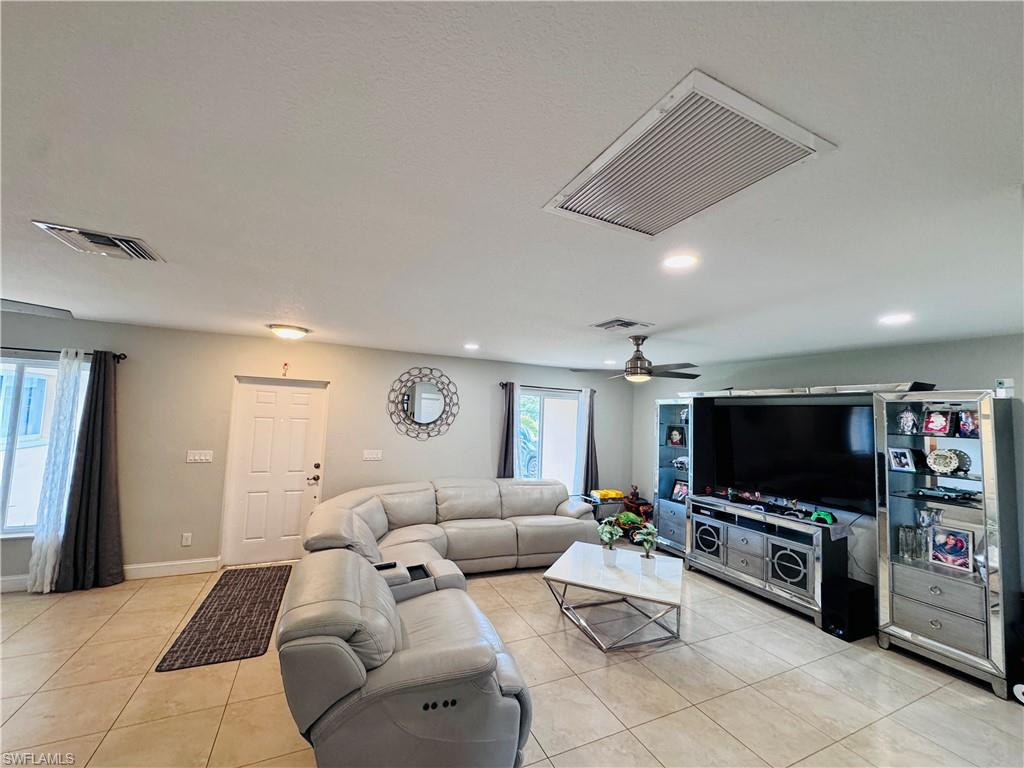 Living area featuring light tile patterned flooring and recessed lighting