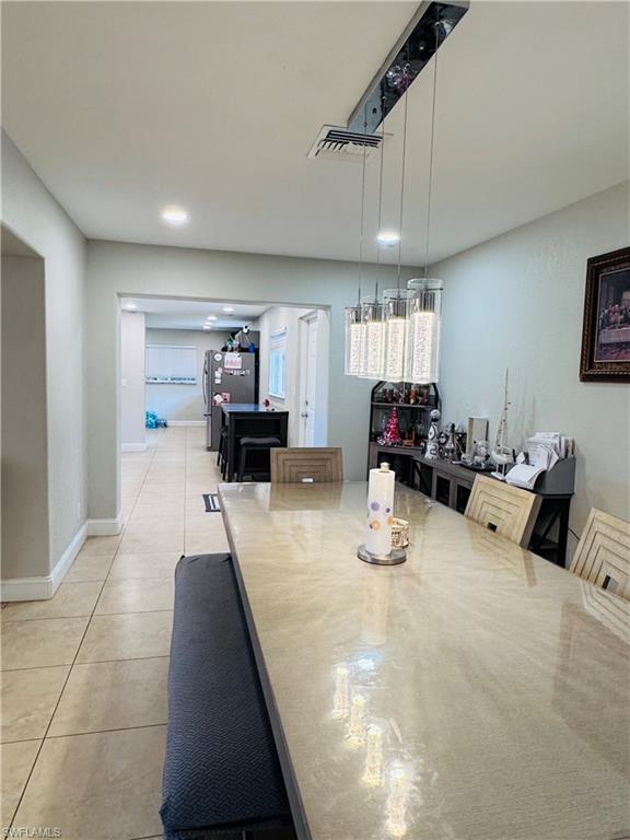 Dining room featuring light tile patterned floors and baseboards