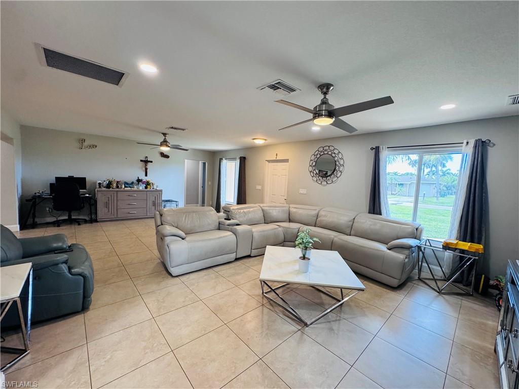 Living room featuring light tile patterned floors, recessed lighting, built in study area, and ceiling fan