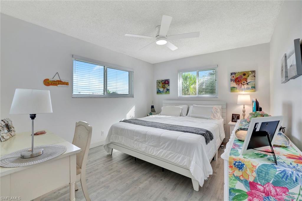 Bedroom featuring light hardwood / wood-style floors, ceiling fan, and a textured ceiling