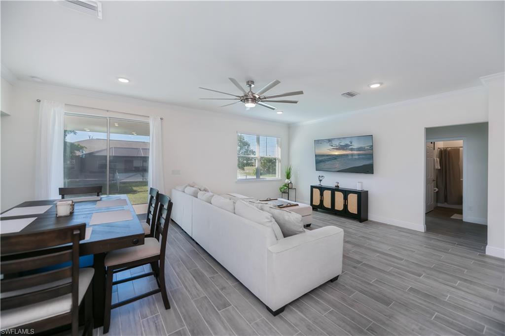 Living area with crown molding, ceiling fan, and recessed lighting