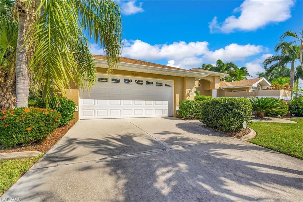 View of front of home with stucco siding, driveway, and an attached garage