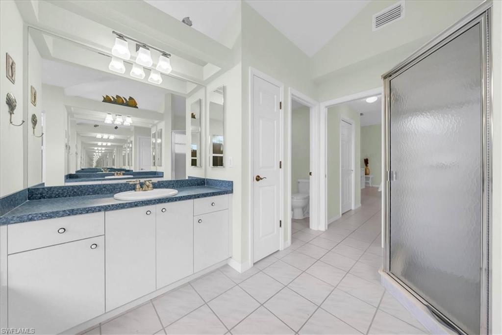 Full bathroom featuring vanity, light tile patterned floors, and a stall shower