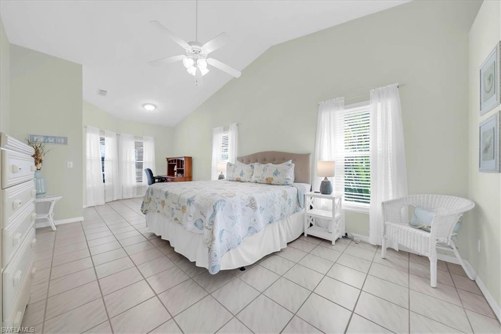 Bedroom with light tile patterned flooring, a ceiling fan, and high vaulted ceiling