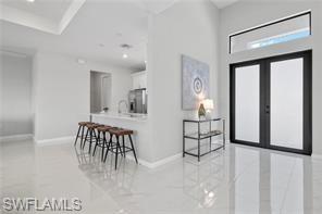 Entryway with french doors, recessed lighting, and light tile patterned floors
