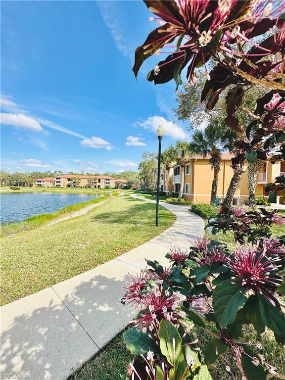 View of property's community featuring a water view and a lawn