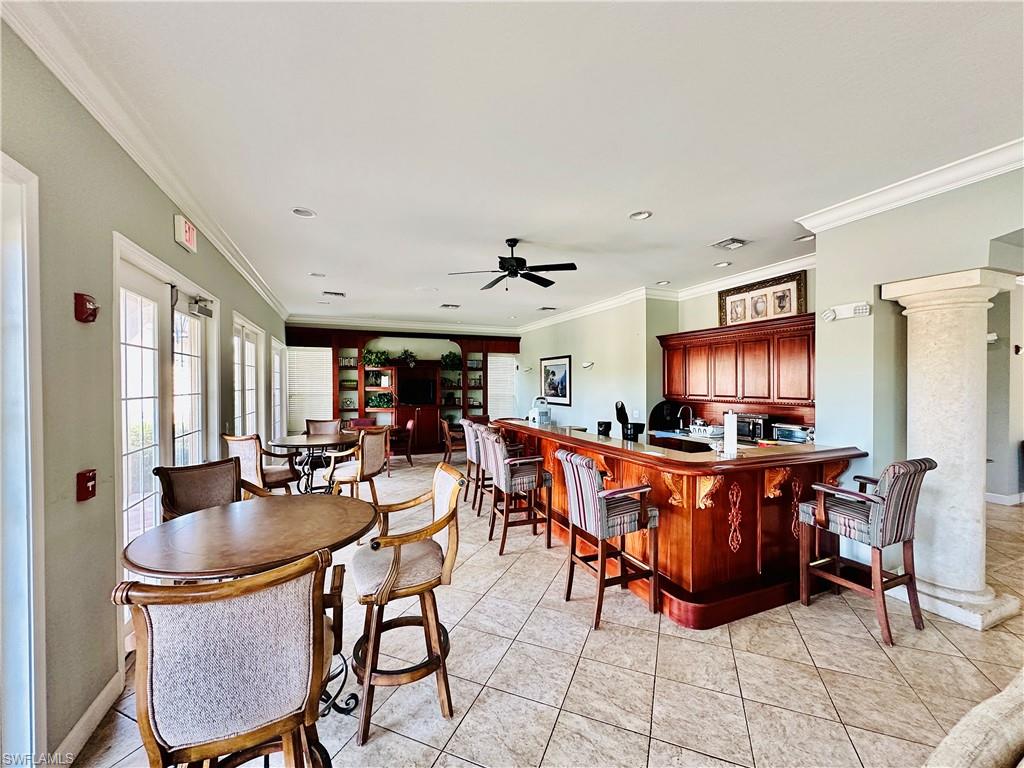 Dining space with ornamental molding, light tile patterned floors, a ceiling fan, and recessed lighting