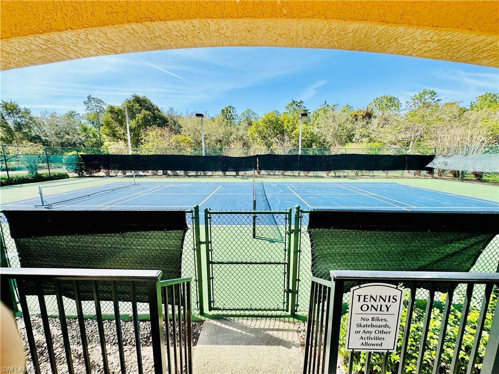 View of tennis court featuring a gate