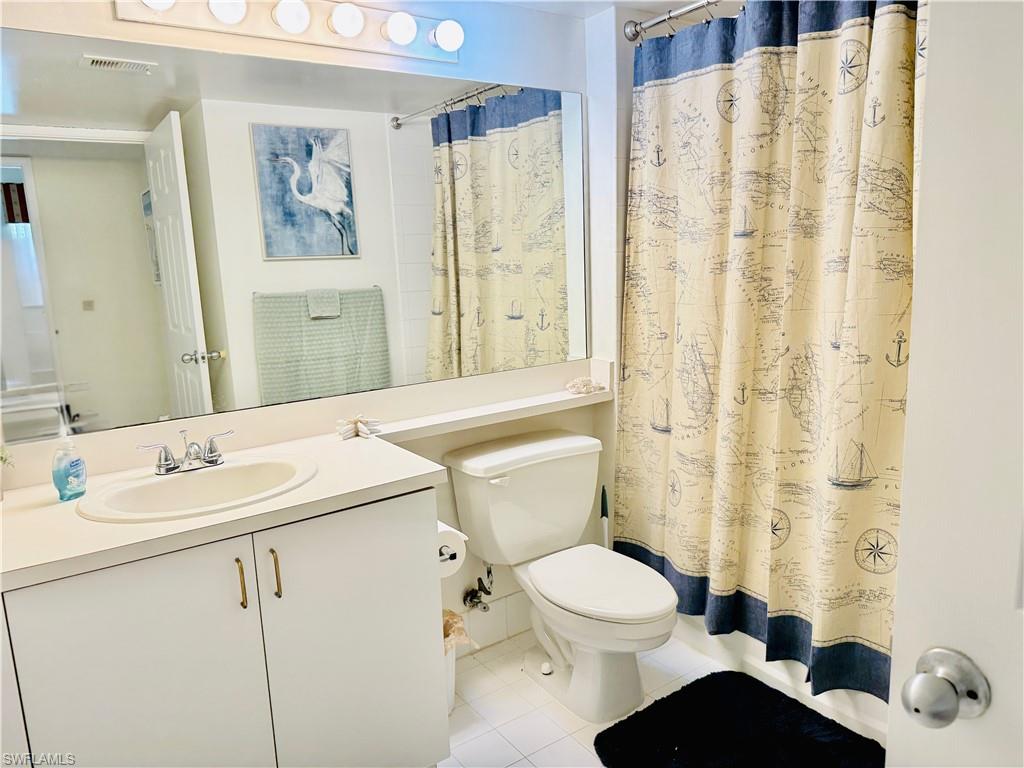 Full bathroom featuring vanity, a shower with shower curtain, and light tile patterned floors