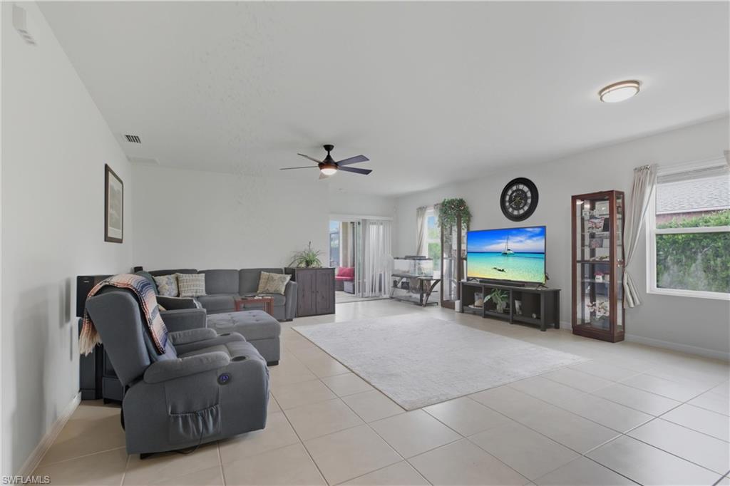 Living area with a ceiling fan and light tile patterned floors