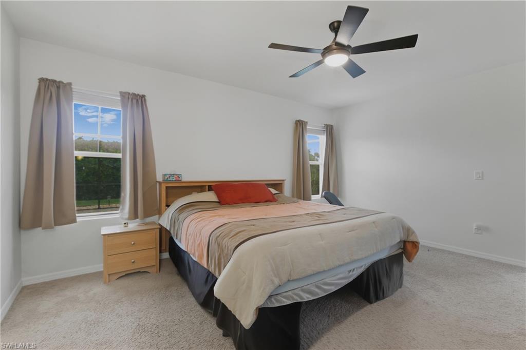 Bedroom with light carpet and a ceiling fan