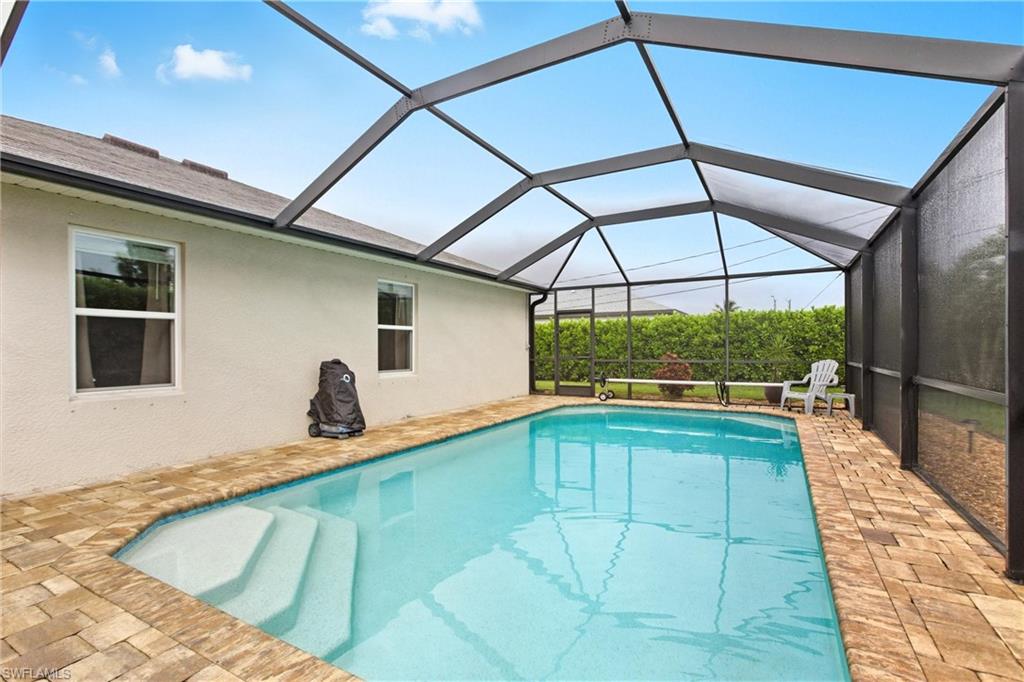 Outdoor pool featuring a patio, a sunroom, and a lanai