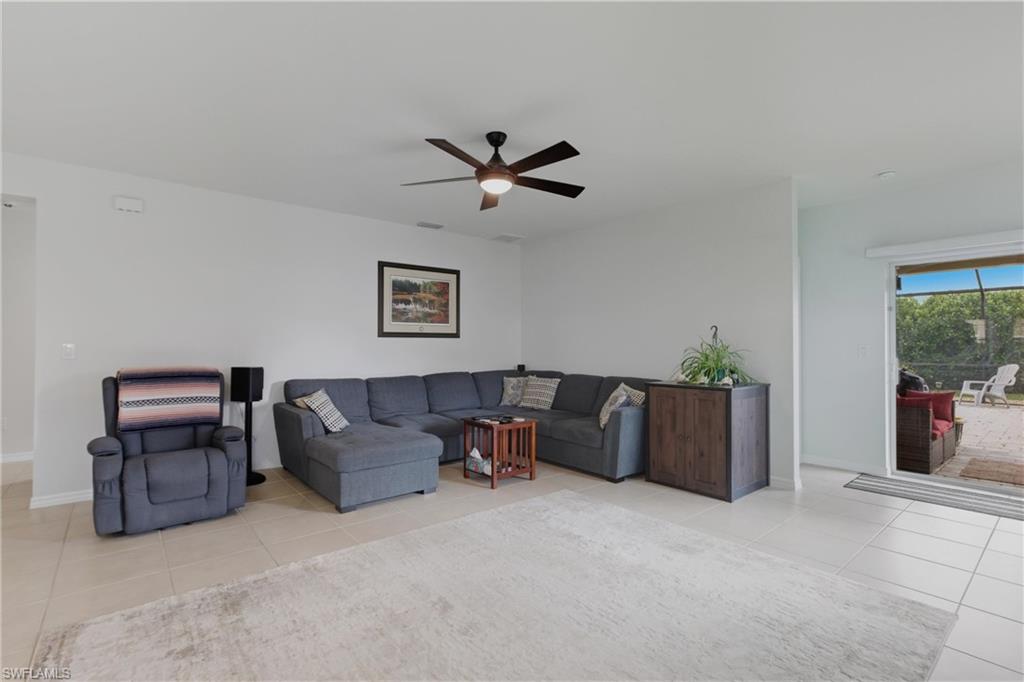 Living area with light tile patterned flooring and ceiling fan