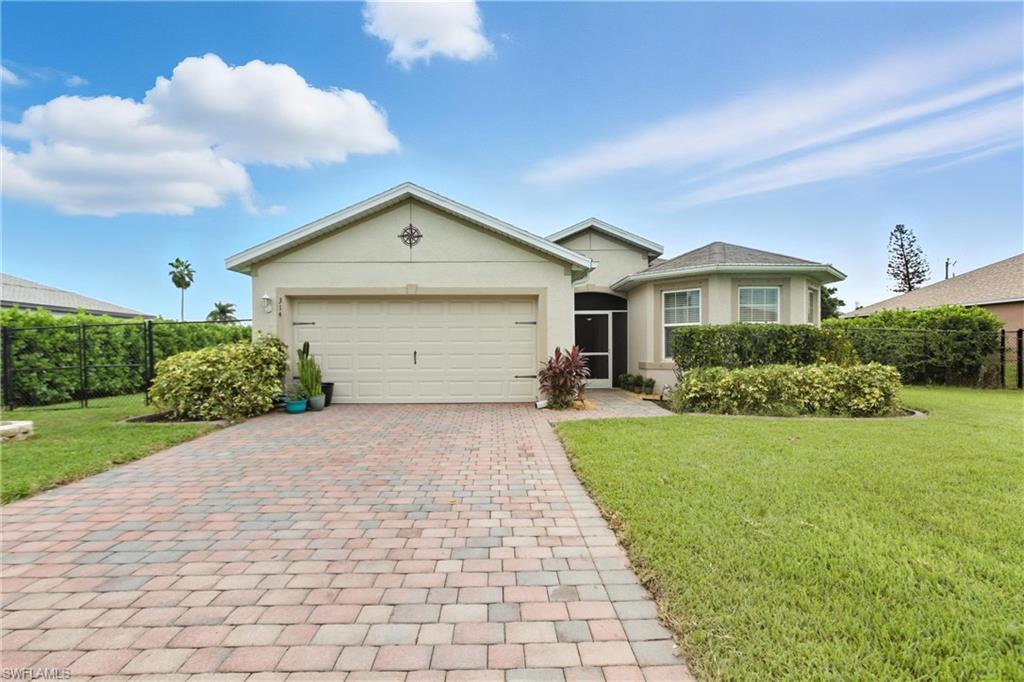 Ranch-style home with stucco siding, decorative driveway, and a garage