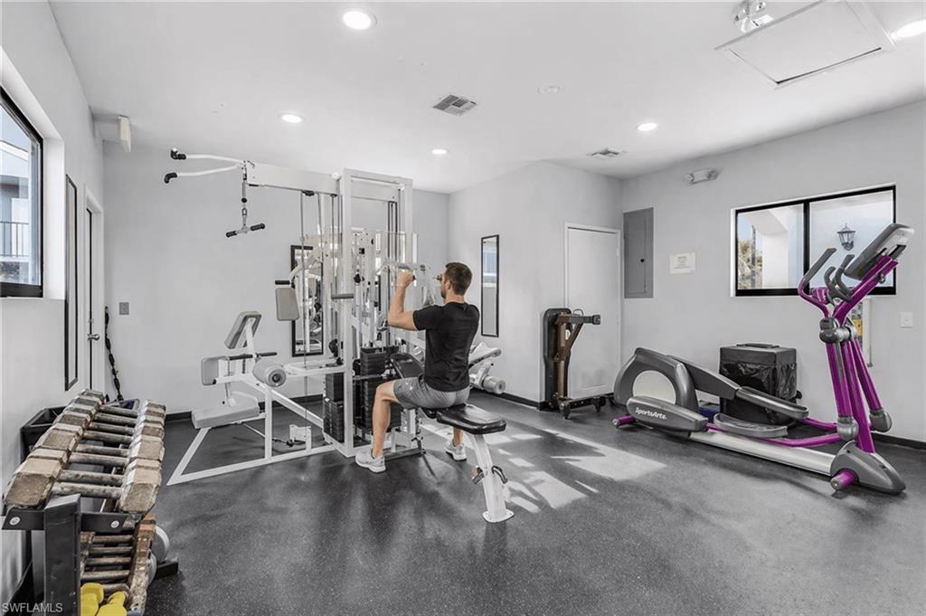 Fitness center featuring a multi-station weight machine, elliptical trainer, and dumbbell rack