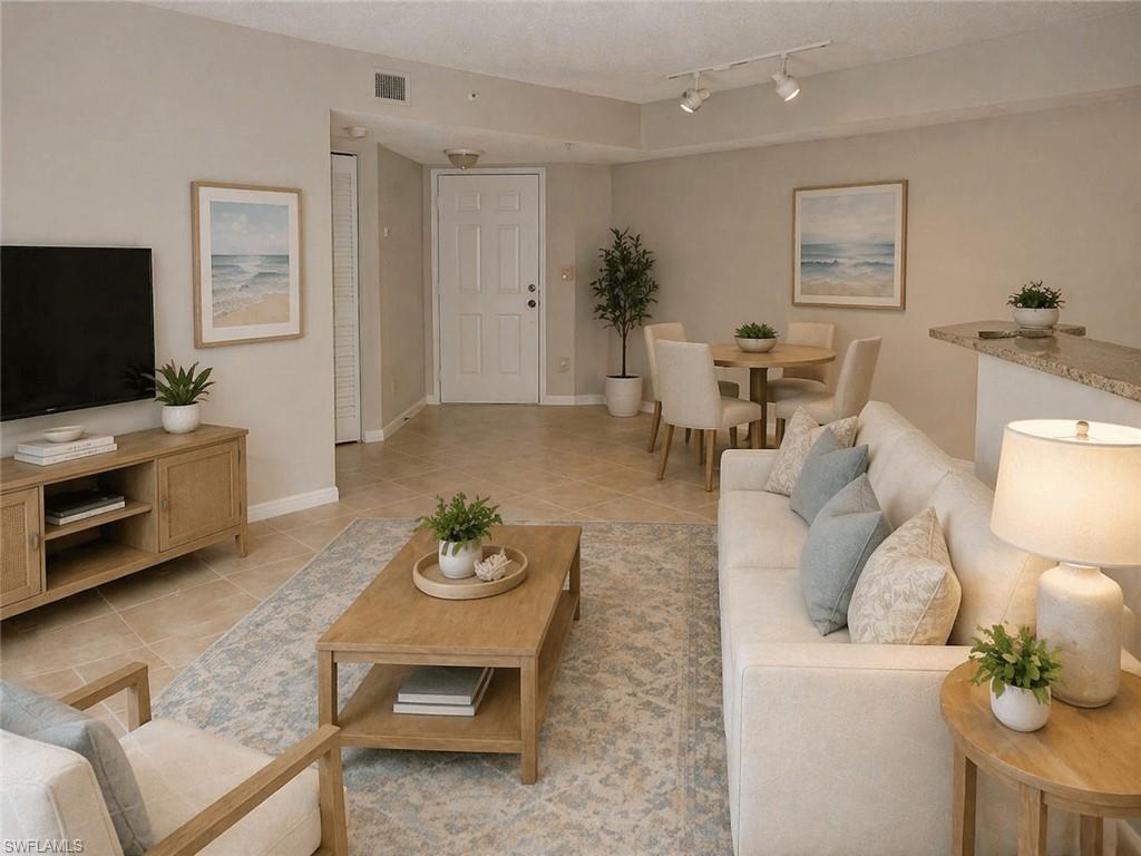 Open-concept living area featuring tile flooring, neutral wall tones, and recessed lighting