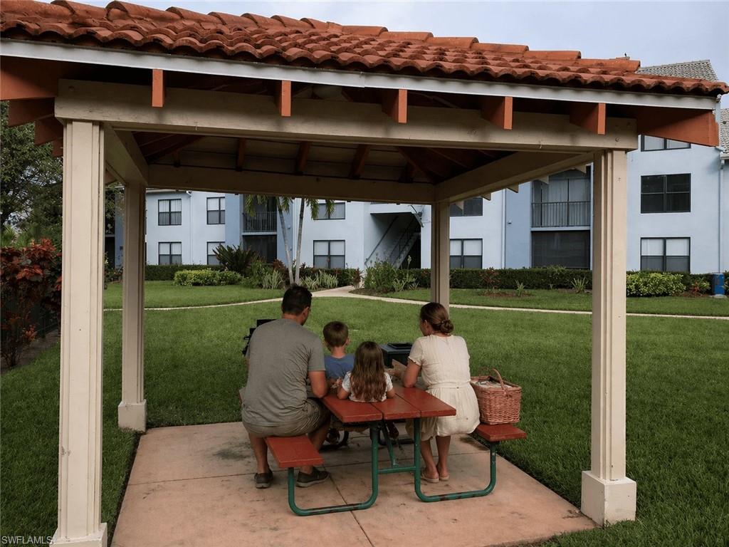 Outdoor pavilion featuring a red tile roof, supporting columns, and a concrete pad