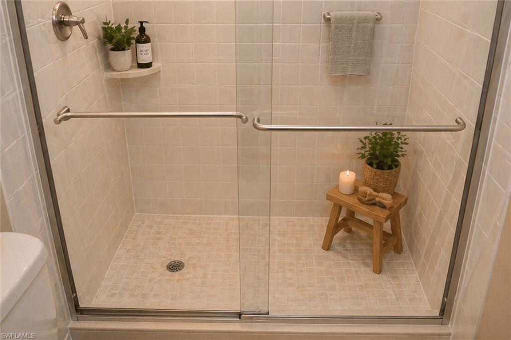 Glass-enclosed shower featuring subway tile walls and a mosaic tile floor