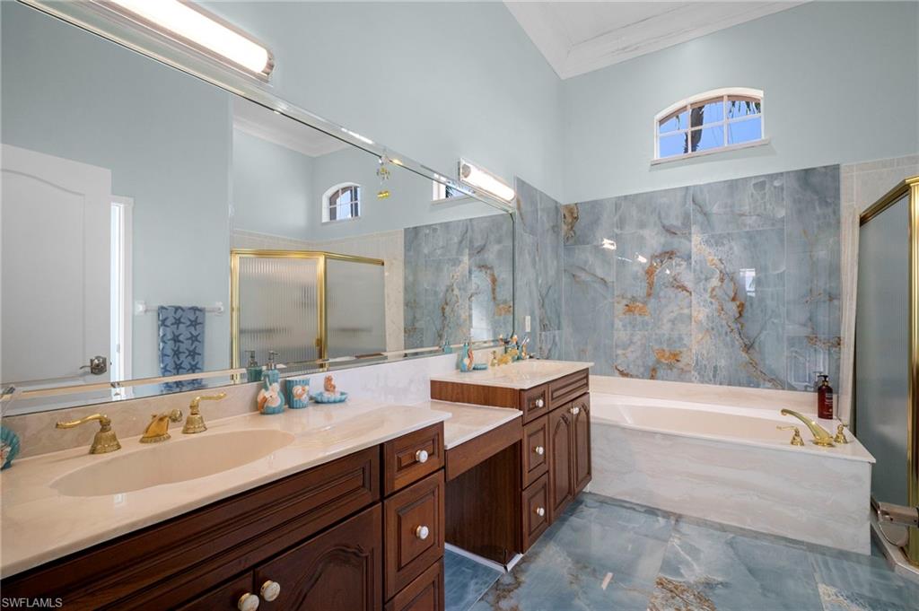 Bathroom with healthy amount of natural light, a bath, a shower stall, and crown molding