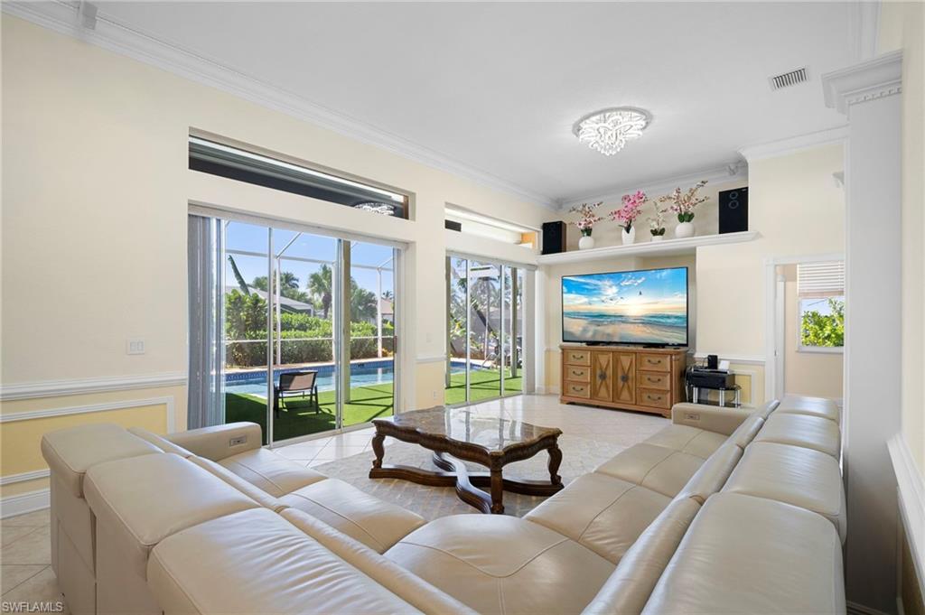 Living room with ornamental molding and light tile patterned flooring