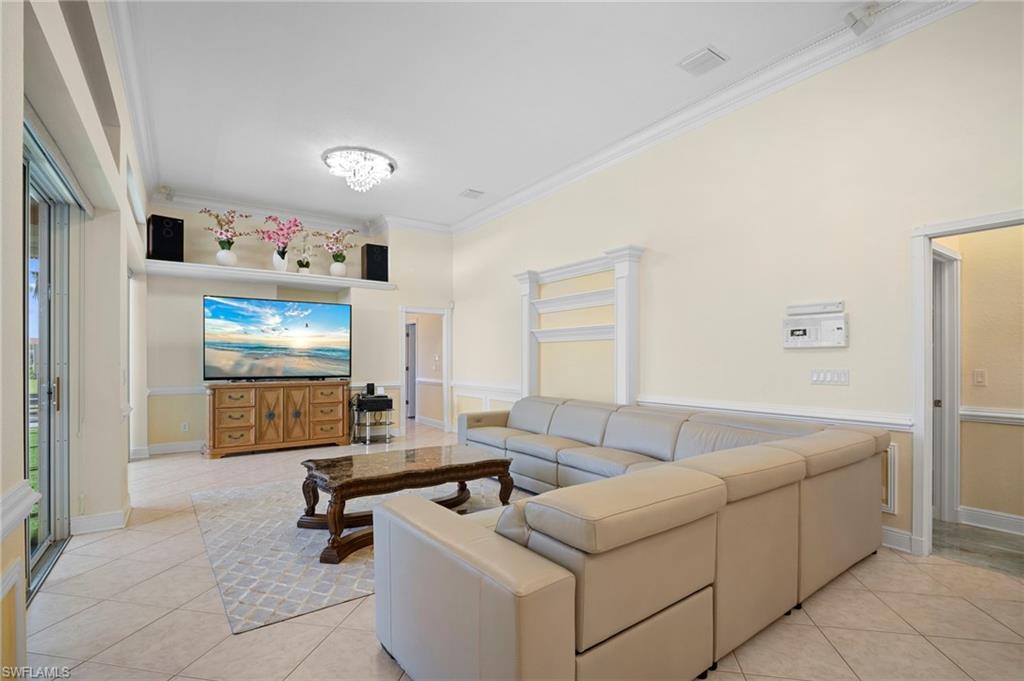 Living room featuring crown molding and light tile patterned floors