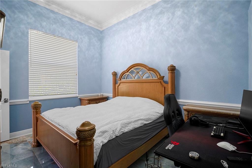 Bedroom with ornamental molding and baseboards