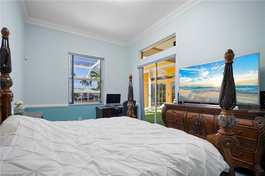Bedroom with crown molding and access to outside