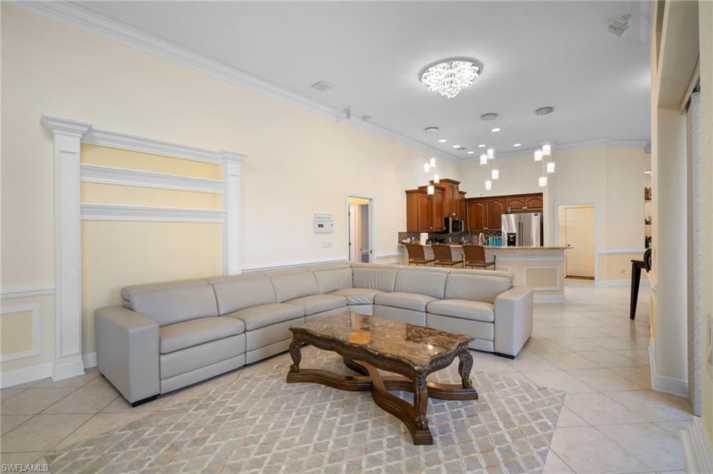 Living area with light tile patterned floors and crown molding
