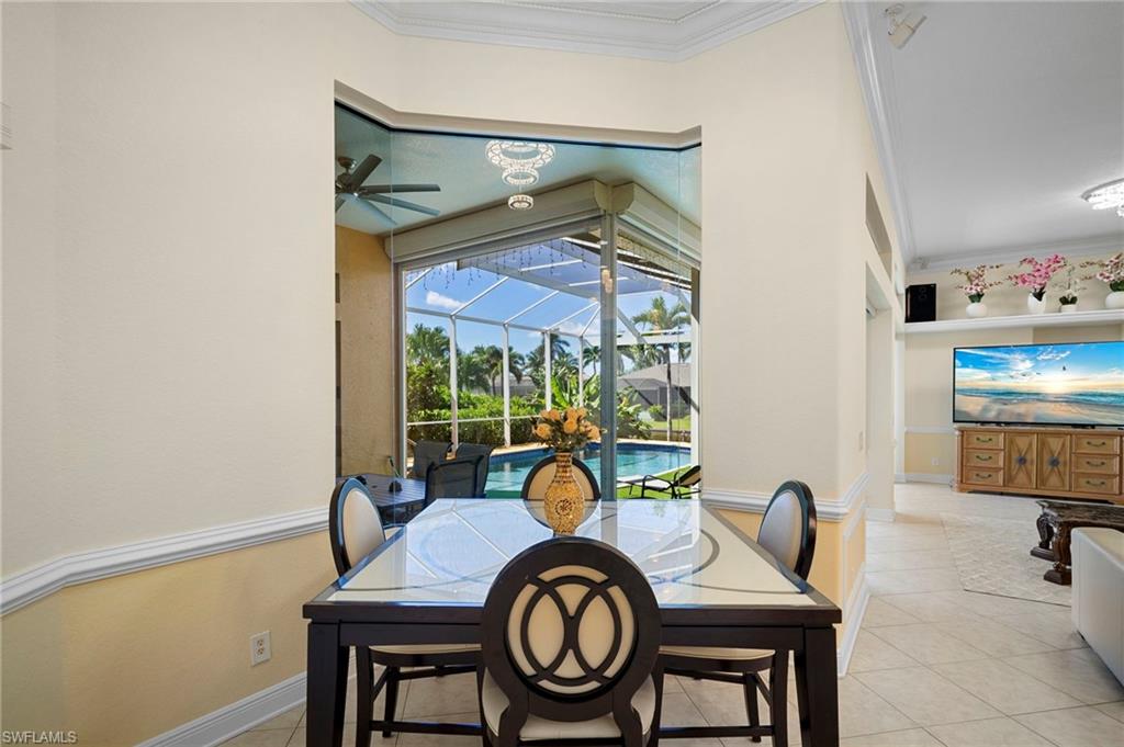 Dining space featuring a sunroom, ornamental molding, light tile patterned floors, and a ceiling fan