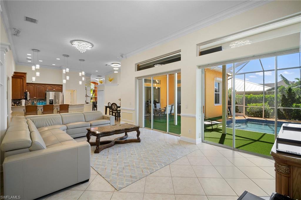 Living area with a sunroom, ornamental molding, and light tile patterned flooring