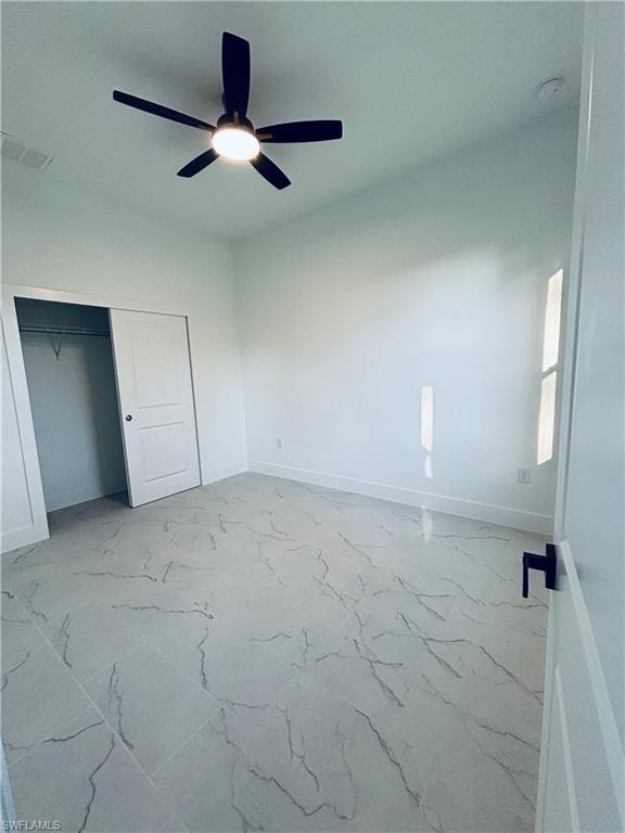 Unfurnished bedroom featuring a closet, ceiling fan, and light marble finish floors
