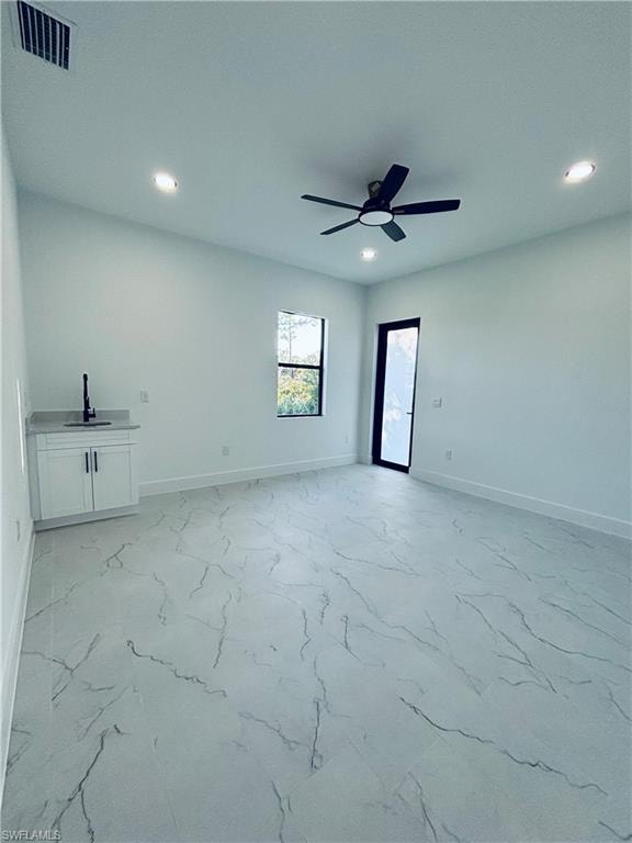 Unfurnished living room with recessed lighting, light marble finish flooring, and ceiling fan