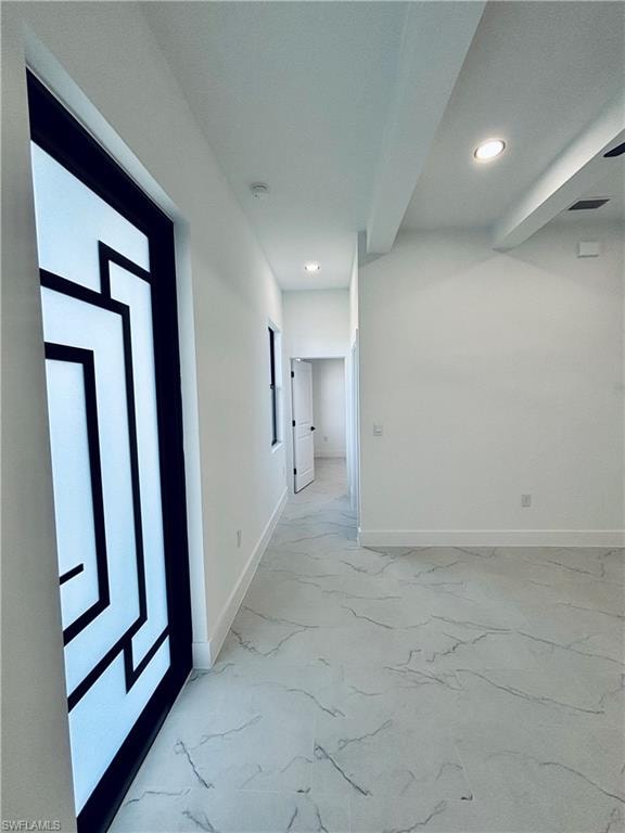 Corridor with light marble finish floors, recessed lighting, and beam ceiling