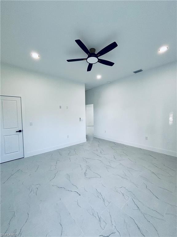 Empty room featuring recessed lighting, light marble finish floors, and ceiling fan