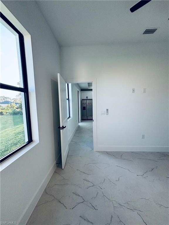 Unfurnished room with light marble finish flooring and ceiling fan