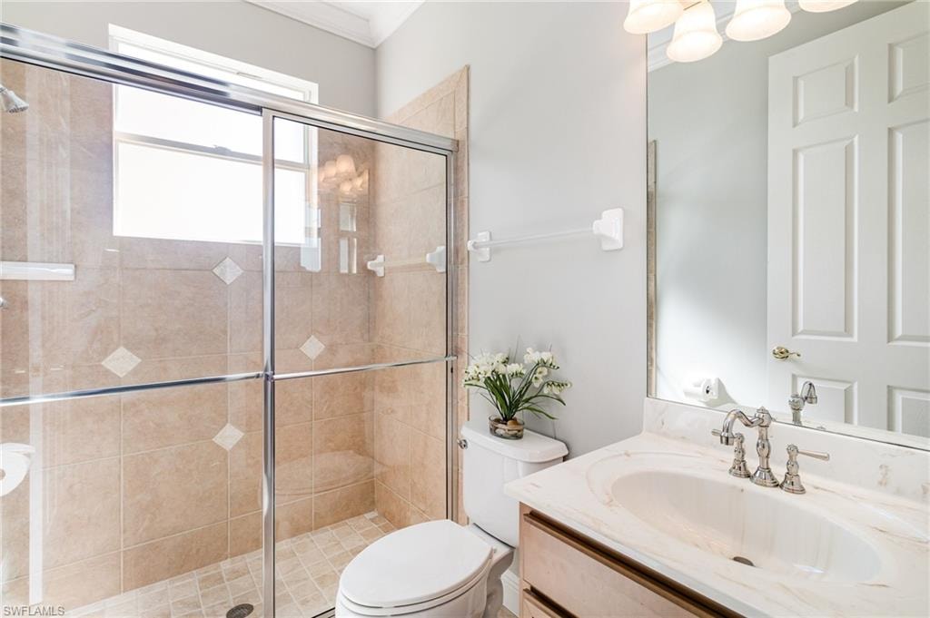 Full bath with vanity, a stall shower, and crown molding
