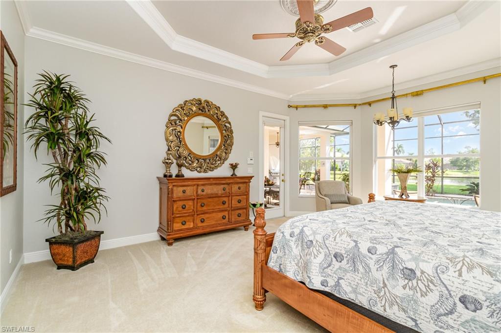 Bedroom featuring a raised ceiling, light carpet, ornamental molding, a ceiling fan, and access to outside