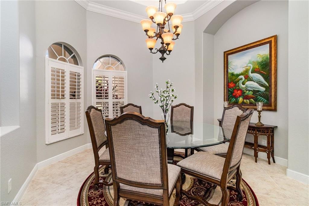 Dining room featuring a chandelier, crown molding, and light tile patterned flooring