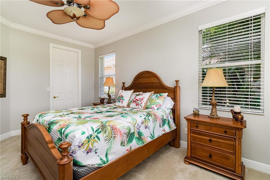 Bedroom featuring crown molding, light carpet, and a ceiling fan