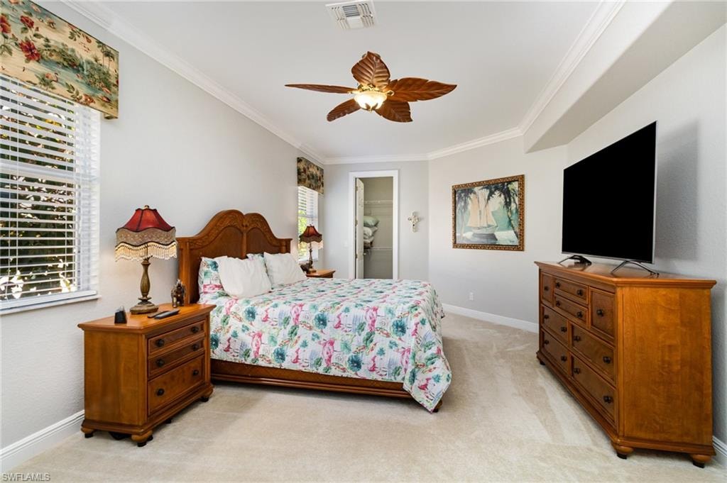Bedroom featuring crown molding, light colored carpet, and ceiling fan